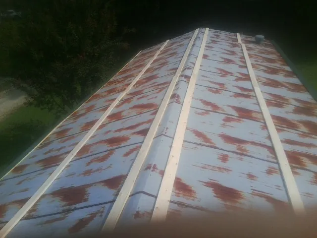 Rusted metal roof panels with new wood purlins before replacement — Storm Damage Roof Repair in Somerville by Roofing Brothers